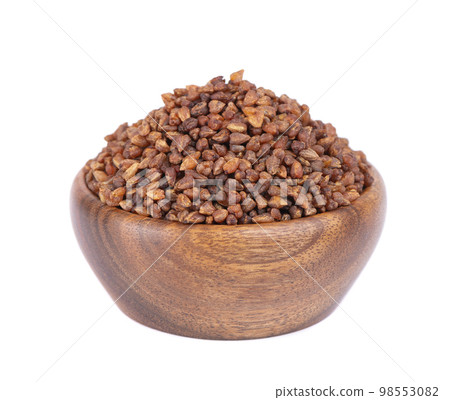 Buckwheat tea in wooden bowl, isolated on white background. Whole roasted buckwheat grains. Fagopyrum tataricum. Buckwheat tea in wooden bowl, isolated on white background. Whole roasted buckwheat grains. Fagopyrum tataricum. 98553082