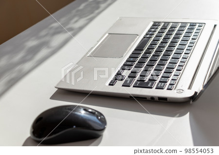 laptop and mouse on desk 98554053