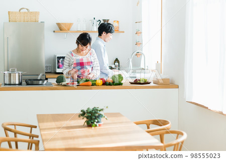 Young couple in the kitchen Young couple in the kitchen 98555023