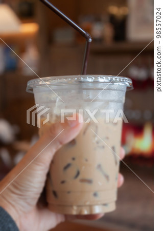 Woman hold her iced coffee Woman hold her iced coffee 98557024