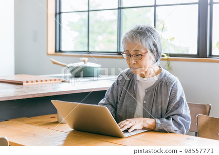 Asian elderly woman using laptop in dining room at home (thinking) Asian elderly woman using laptop in dining room at home (thinking) 98557771