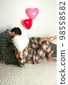 A couple of lovers hold a large balloon in the shape of a heart. The concept of Valentine's Day. Front view. 98558582