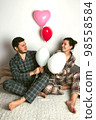 Couple of lovers holds balloons in the shape of a heart. The concept of Valentine's Day. Front view. 98558584