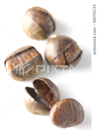 Photographing sweet chestnuts against a white background 98559135