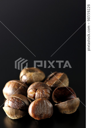 Photographing sweet chestnuts on a black background Photographing sweet chestnuts on a black background 98559226