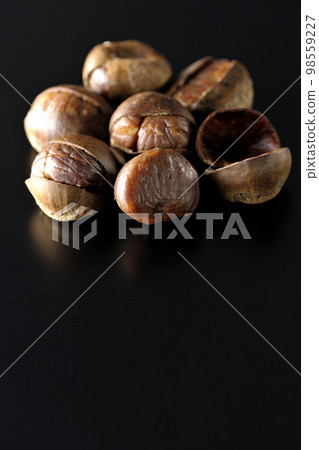 Photographing sweet chestnuts on a black background Photographing sweet chestnuts on a black background 98559227