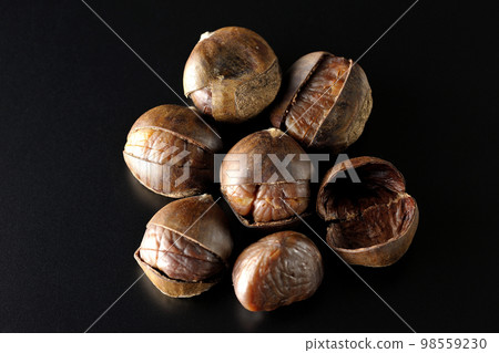 Photographing sweet chestnuts on a black background Photographing sweet chestnuts on a black background 98559230