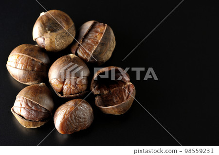 Photographing sweet chestnuts on a black background 98559231