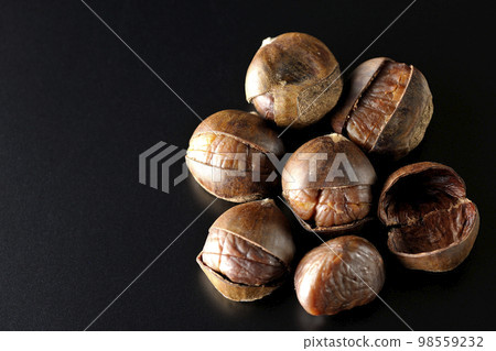 Photographing sweet chestnuts on a black background Photographing sweet chestnuts on a black background 98559232