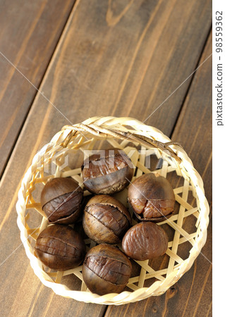 sweet chestnuts in a bamboo basket sweet chestnuts in a bamboo basket 98559362