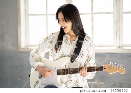 Young woman portrait (electric guitar) Young woman portrait (electric guitar) 98559562