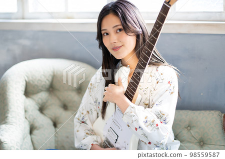Young woman portrait (electric guitar) Young woman portrait (electric guitar) 98559587