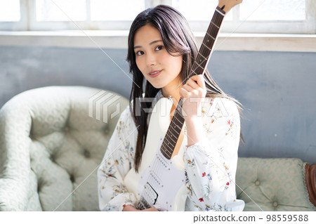 Young woman portrait (electric guitar) Young woman portrait (electric guitar) 98559588