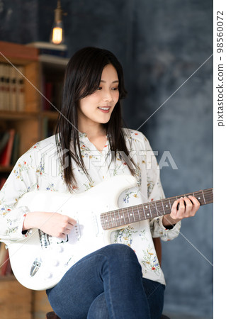 Young woman portrait (electric guitar) 98560072