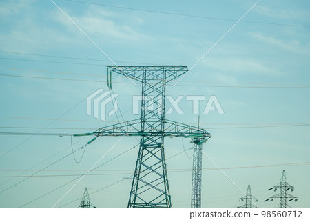 Power line support with wires for electricity transmission. Silhouette High voltage grid tower with wire cable at distribution station. energy industry, energy saving 98560712
