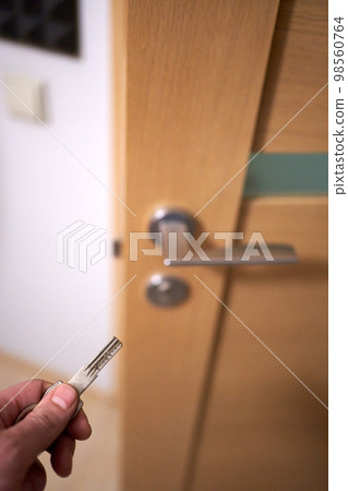 Closeup of man's hand going to close the half opened interior door Closeup of man's hand going to close the half opened interior door 98560764