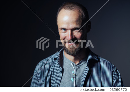 Closeup portrait of a mature man smiling at camera with confusion Closeup portrait of a mature man smiling at camera with confusion 98560770