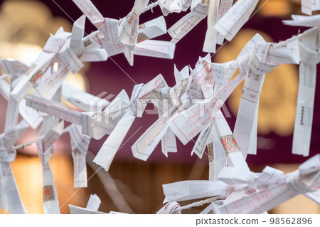 Many omikuji left in the precincts of the shrine 98562896