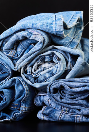 Many twisted jeans on a dark background Many twisted jeans on a dark background 98563533