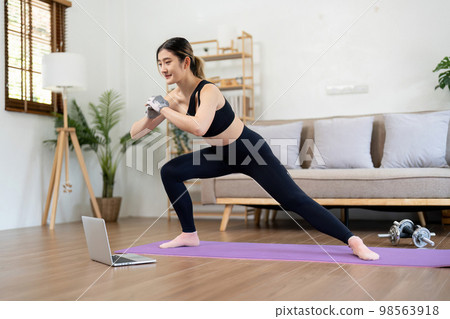 Fit asian woman training fitness exercise sport workout online class on laptop computer at home 98563918