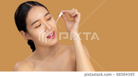 Beauty asian woman portrait dropping essential oil on clean face. Beauty asian woman portrait dropping essential oil on clean face. 98564395