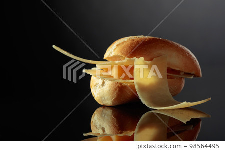 Sandwich with Parmesan cheese on a black background. Sandwich with Parmesan cheese on a black background. 98564495
