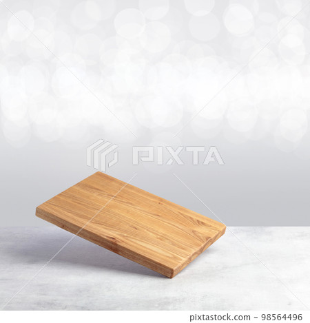 Cutting board falling on a grey stone table. Cutting board falling on a grey stone table. 98564496
