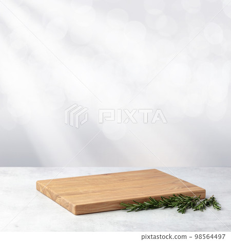 Cutting board and rosemary on a grey stone table. Cutting board and rosemary on a grey stone table. 98564497