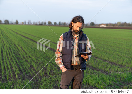 Farmer with digital tablet on a field. Farmer with digital tablet on a field. 98564697