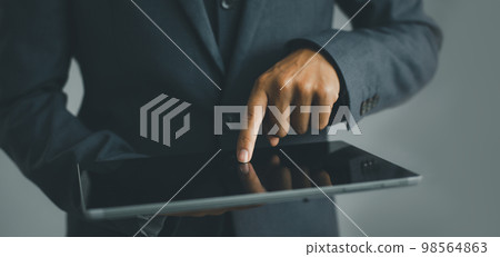 Businessman using a tablet in hand, technology concept background. 98564863