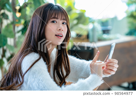 A young woman using a smartphone A young woman using a smartphone 98564977