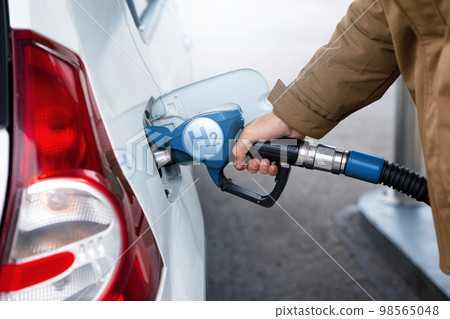 A man fuels a car with hydrogen. 98565048