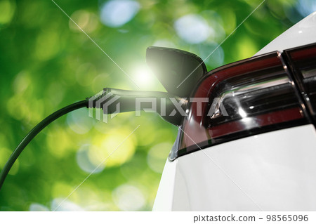 Close up of electric car inlet with a connected charging cable Close up of electric car inlet with a connected charging cable 98565096