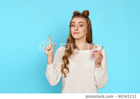 woman with drinking glass of water pointing up woman with drinking glass of water pointing up 98565211