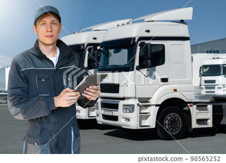 Manager with a digital tablet next to trucks. 98565252