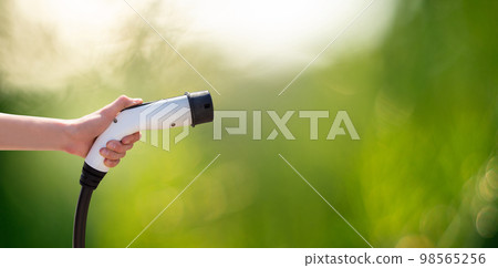 Hand with charger plug for electric car 98565256