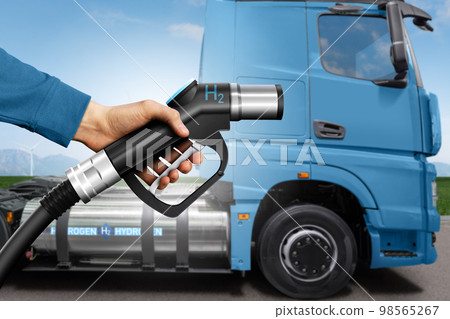 Hand with H2 fueling nozzle on a background of hydrogen fuel cell semi truck with Hand with H2 fueling nozzle on a background of hydrogen fuel cell semi truck with 98565267