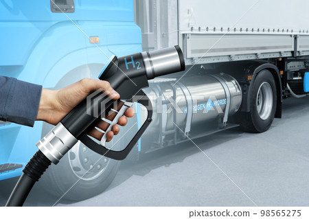Hand with H2 fueling nozzle on a background of hydrogen fuel cell semi truck with Hand with H2 fueling nozzle on a background of hydrogen fuel cell semi truck with 98565275