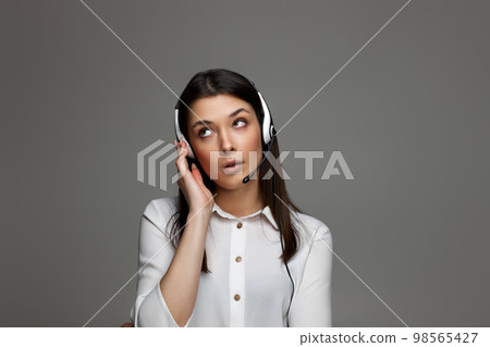 friendly smiling woman with headset is consulting clients online. friendly smiling woman with headset is consulting clients online. 98565427