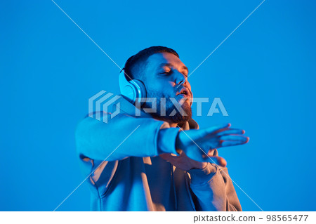 man with headphones in sweatshirt enjoying favorite music 98565477