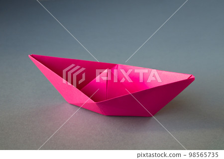 Pink paper boat origami isolated on a grey background 98565735