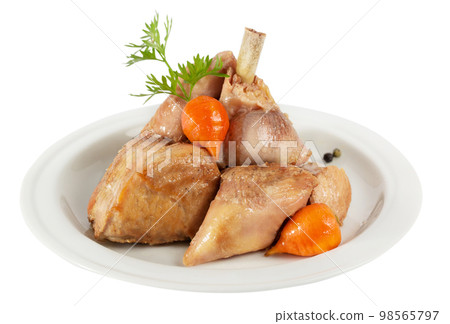Chicken pieces with glazed mini carrots served on a plate 98565797