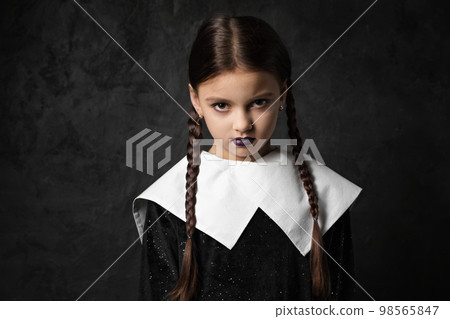 A sullen girl with pigtails in a black dress with a white collar 98565847