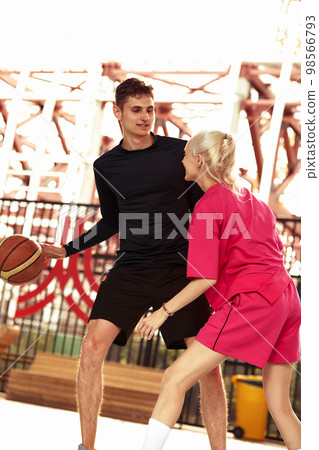 Diversity guy and girl playing basketball on the city playground 98566793