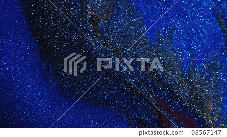Sparkling background. Glitter texture. Galaxy nebula. Defocused shimmering blue purple black color grain glow on dark abstract free space. 98567147