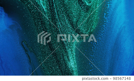 Glitter ink. Abstract background. Sparkling wave. Defocused shiny shimmering green blue color liquid paint blend grain texture with free space. 98567148