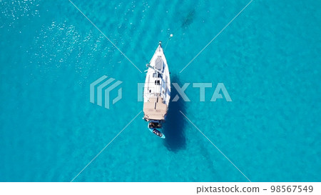 Top view of the white luxury wooden boat in coral sea blue water Top view of the white luxury wooden boat in coral sea blue water 98567549