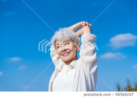 Senior woman stretching under the blue sky 98568287