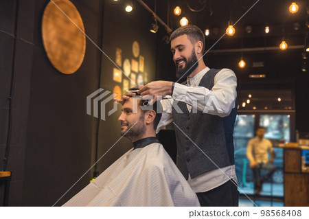 Male hairdresser working with the client in the babershop Male hairdresser working with the client in the babershop 98568408