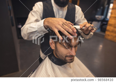 Male hairdresser working with the client in the babershop Male hairdresser working with the client in the babershop 98568410